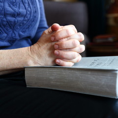 prayer/ hands folded in prayer on the bible