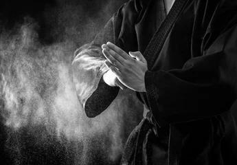 Foto op Plexiglas Vechtsport Close-up van de mannelijke handen van de karatevechter. Zwart en wit.