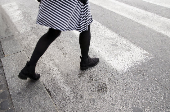 ragazza con delle belle gambe che attraversa la strada sulle strisce pedonali a Roma