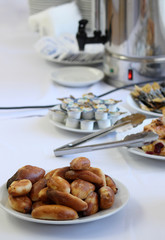 Catering banquet table with baked food snacks, cakes, coffee and coffee creamers, self serve, open...