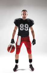 American football player posing with ball on white background