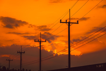 Silhouette electricity post with beautiful sunset background.