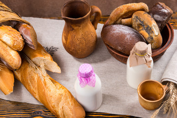 Old wooden pitcher, milk and bread