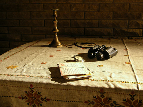 Table with candlestick and binoculars.