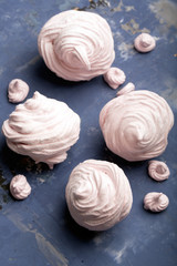 Delicious pink meringue on the blue table