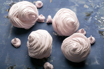 Delicious pink meringue on the blue table