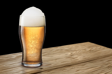Glass of light beer on wooden table