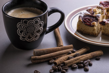 A Cup of coffee with cinnamon and coffee beans