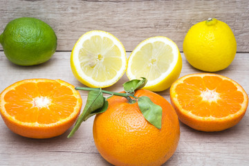 several mature citrus on a wooden table - lemon, lime and tangerine
