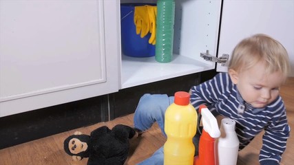 Smal child playing with toxic household cleaners
