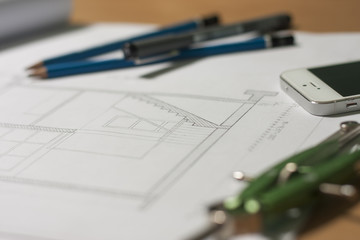 Architectural blueprints and blueprint rolls and a drawing instruments on architects desk