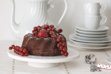 Chocolate cake with fresh berries set in a white tableware