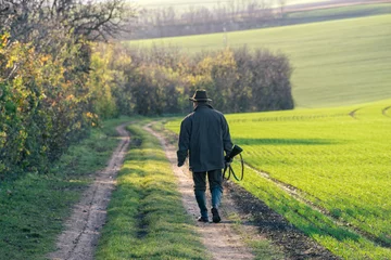 Foto op Plexiglas Schilderachtig uitzicht van jachtopziener loopt over veld. © 1tomm