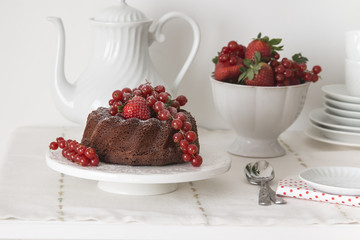 Chocolate cake with fresh berries set in a white tableware