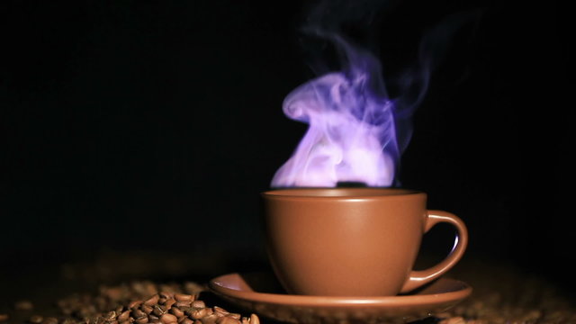 Cup of hot coffee, grains with steam   in orange tone . 