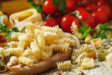 Uncooked pasta spiraline, vegetables, herbs and spices, selectiv