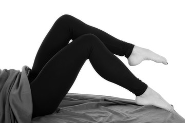 woman legs in black tight pants barefoot knees up - obrazy, fototapety, plakaty