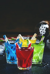 Colorful cocktails with straws on a dark background, selective f