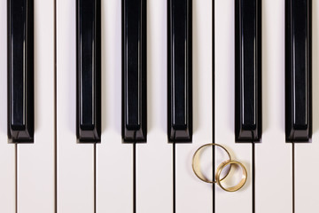 Naklejka premium Piano keyboard and wedding rings