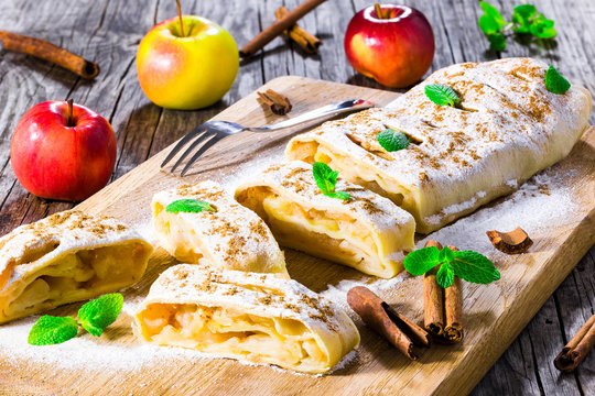 baked homemade apple strudel with powdered sugar and mint leaves
