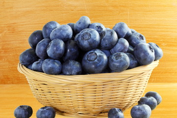 blueberries in bamboo basket closeup on wooden desk background