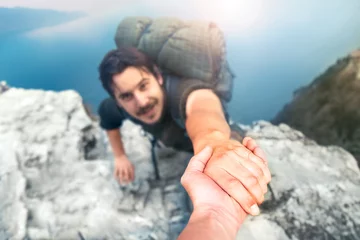 Foto op Plexiglas adventurers helping each other to climb the mountain © fran_kie