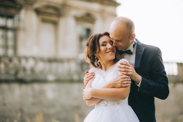 Naklejka premium couple after wedding in tne park near the castle