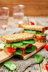 Smashed avocado spinach tomato grilled rye sandwich
