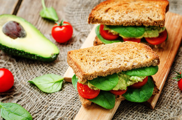 Smashed avocado spinach tomato grilled rye sandwich