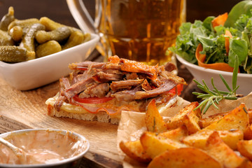 Sandwich with shredded pork, roasted potatoes and salad