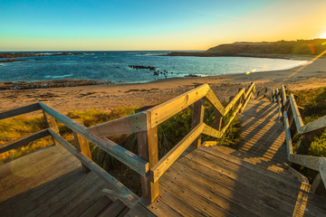 Wooden boardwalks to the beach of Kitty Miller Bay at sunset, in Phillip Island, Victoria, Australia.