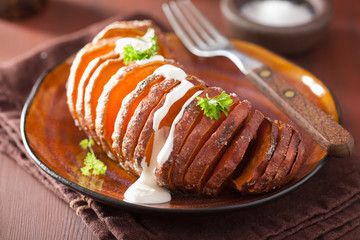 Baked hasselback potato with sour cream