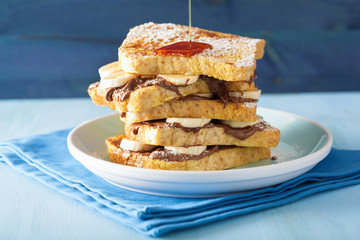 pouring caramel over french toasts with banana chocolate sauce f