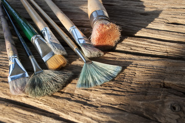 Verschiedene, gebrauchte Pinsel auf Holz / Treibholz Hintergrund