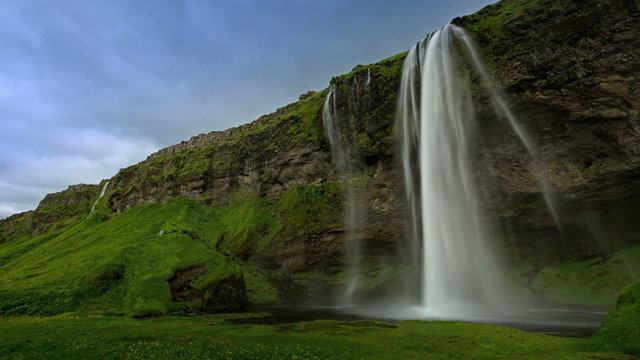 4K TimeLapse. Seljalandsfoss - one of the most famous waterfalls in Iceland. The waterfall is located on the river Seljalandsá and stands 60m over the cliffs. Iceland, 15 June 2015