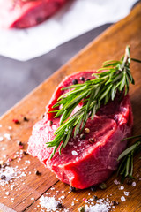 Steak. Raw beef steak. Fresh raw Sirloin beef steak sliced or whole ready for BBQ or grill. Herb - Rosemary decoration.