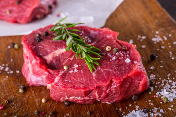 Steak. Raw beef steak. Fresh raw Sirloin beef steak sliced or whole ready for BBQ or grill. Herb - Rosemary decoration.