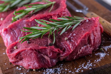 Steak. Raw beef steak. Fresh raw Sirloin beef steak sliced or whole ready for BBQ or grill. Herb - Rosemary decoration.