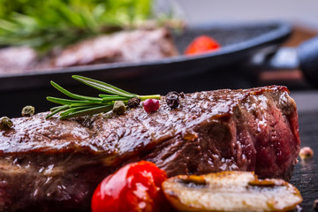 Grill beef steak. Portions thick beef juicy sirloin steaks on grill teflon pan or old wooden board.