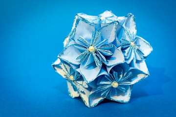 Blue origami flower ball on the blue background