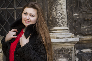 Fototapeta premium Beautiful brunette woman in a black fur coat