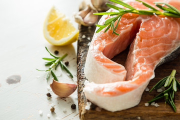 Raw salmon steaks on rustic background