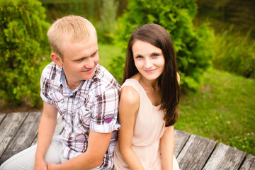 Fototapeta na wymiar Young hip couple laughing on bench in the park