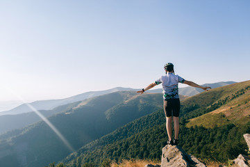 Naklejka premium biker man jumps from the cliff in mountains