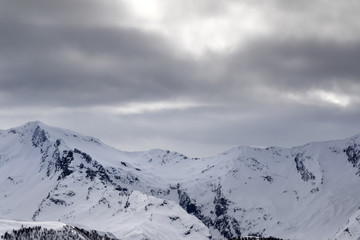 Fototapeta na wymiar Snowy mountains and gray sky before blizzard