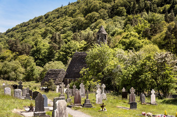 Naklejka premium Ruin of an old chapel with graveyards and tombstones in Glendalough Ireland