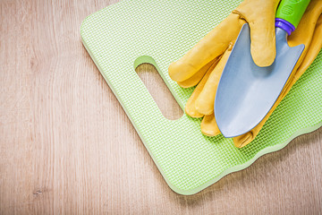 Leather safety gloves metal hand spade garden knee mat on wooden