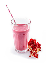 Pomegranate smoothie with straw next to fruit