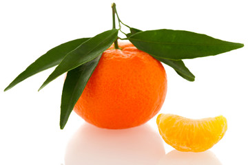 Fresh unpeeled orange mandarin citrus with green leafs and half