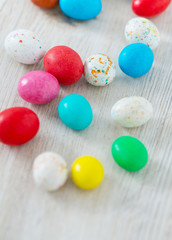 Fototapeta na wymiar Easter candy eggs on white wooden surfae